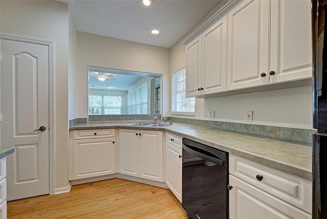 kitchen with dishwasher, a textured ceiling, white cabinets, and sink