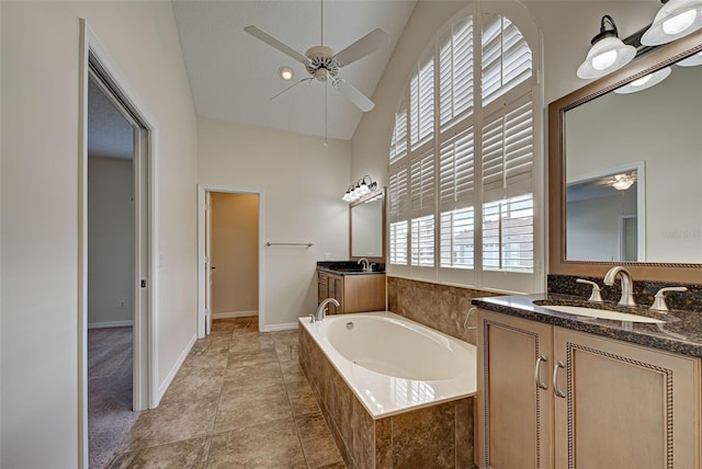 bathroom with vanity, tile patterned floors, vaulted ceiling, ceiling fan, and tiled tub