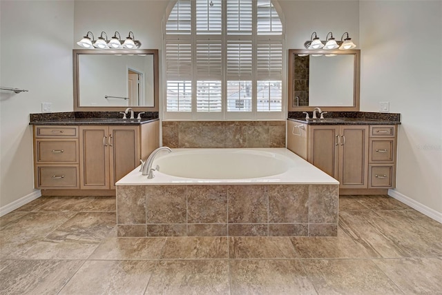 bathroom featuring tiled bath and vanity