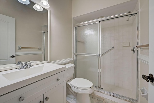 bathroom featuring tile patterned flooring, vanity, toilet, and an enclosed shower