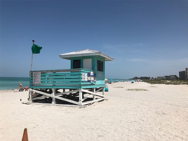 view of community with a water view and a beach view