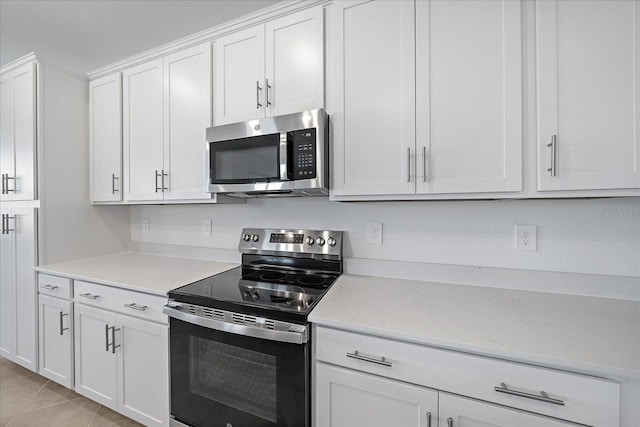 kitchen with white cabinetry, appliances with stainless steel finishes, and light tile patterned floors