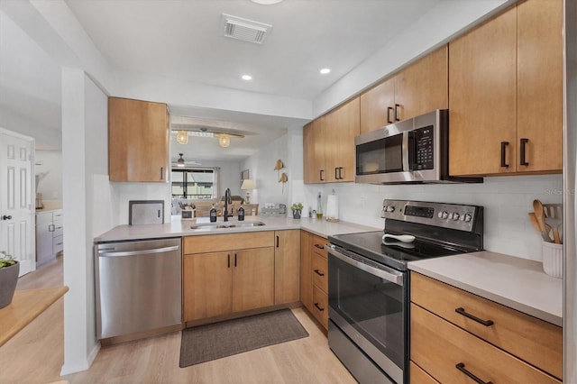 kitchen featuring light hardwood / wood-style flooring, appliances with stainless steel finishes, sink, and decorative backsplash