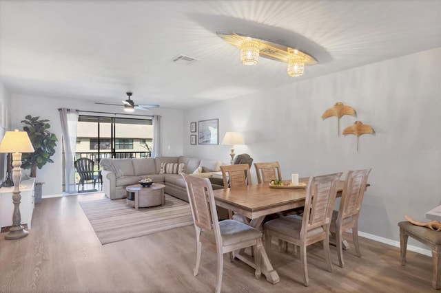 dining space with ceiling fan and wood-type flooring