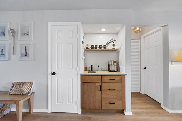 bar featuring sink and light wood-type flooring