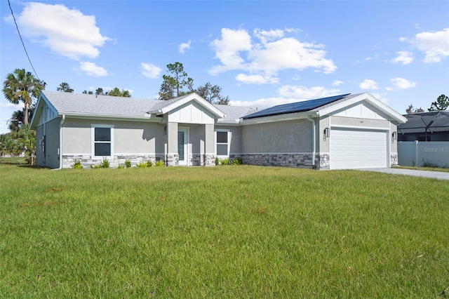 view of front of home with solar panels, a front lawn, and a garage