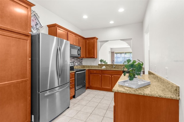 kitchen featuring tasteful backsplash, sink, light tile patterned floors, kitchen peninsula, and stainless steel appliances