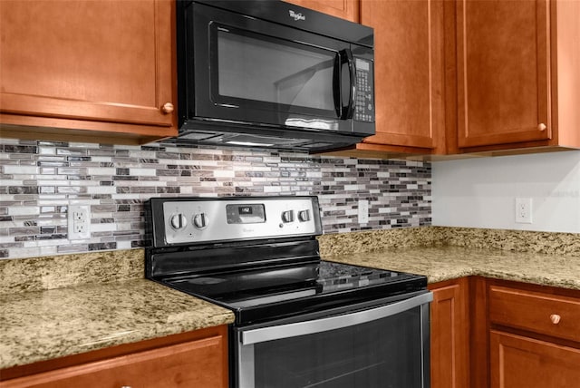 kitchen with stainless steel electric range oven, light stone countertops, and decorative backsplash