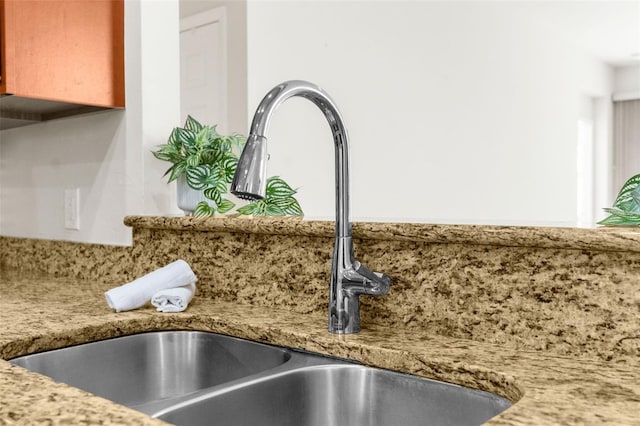 interior details featuring light stone counters and sink