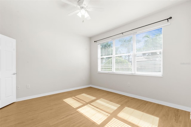 spare room featuring a healthy amount of sunlight, ceiling fan, and light hardwood / wood-style flooring