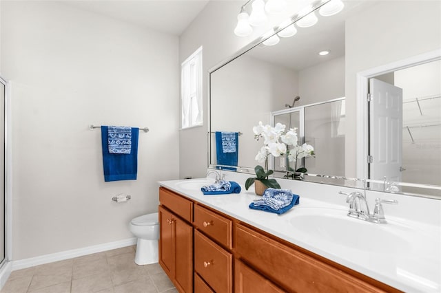 bathroom with vanity, a shower with shower door, tile patterned floors, and toilet