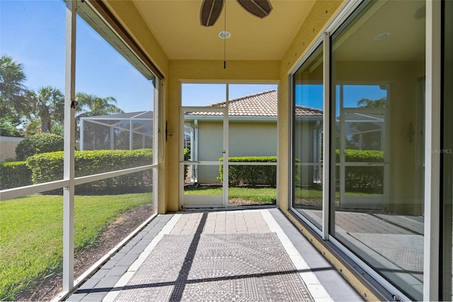 unfurnished sunroom with ceiling fan