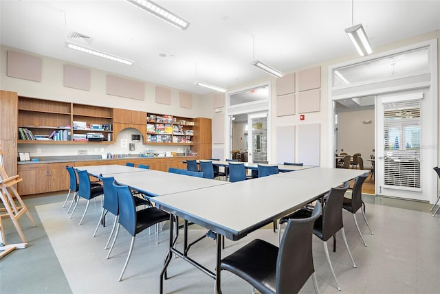 dining room featuring a healthy amount of sunlight and a high ceiling