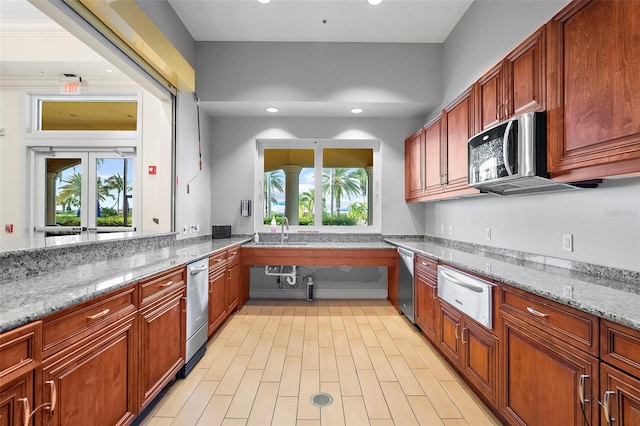 kitchen featuring stainless steel appliances, sink, light stone counters, and french doors