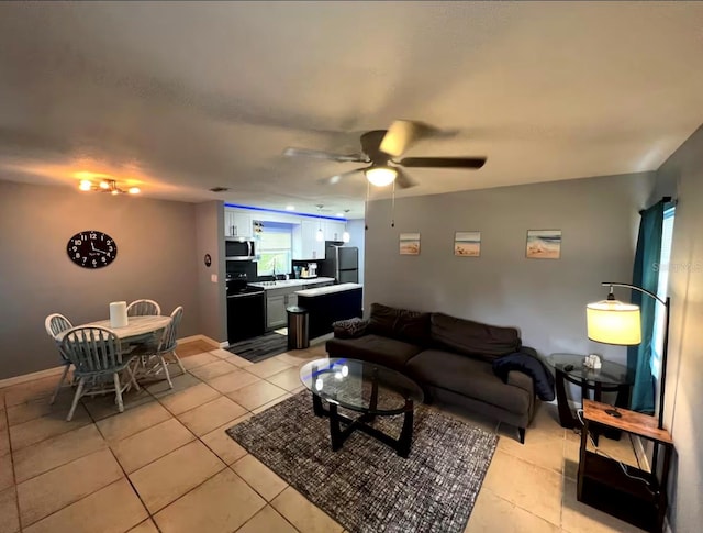 living room featuring sink, light tile patterned floors, and ceiling fan