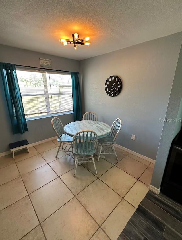 tiled dining room with a textured ceiling