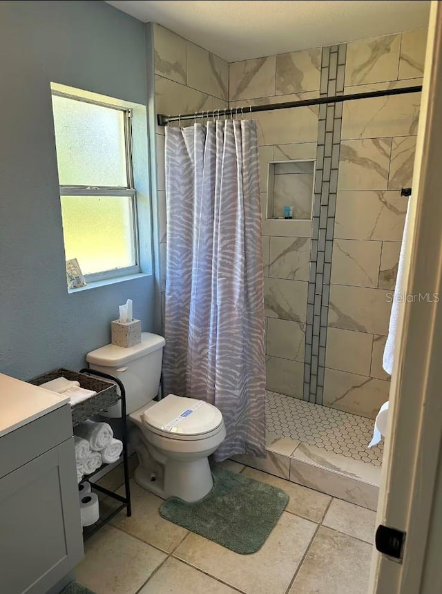 bathroom with vanity, toilet, tile patterned floors, and curtained shower