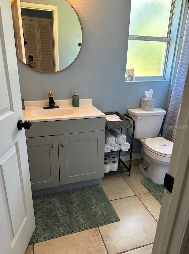 bathroom with vanity, toilet, and tile patterned flooring