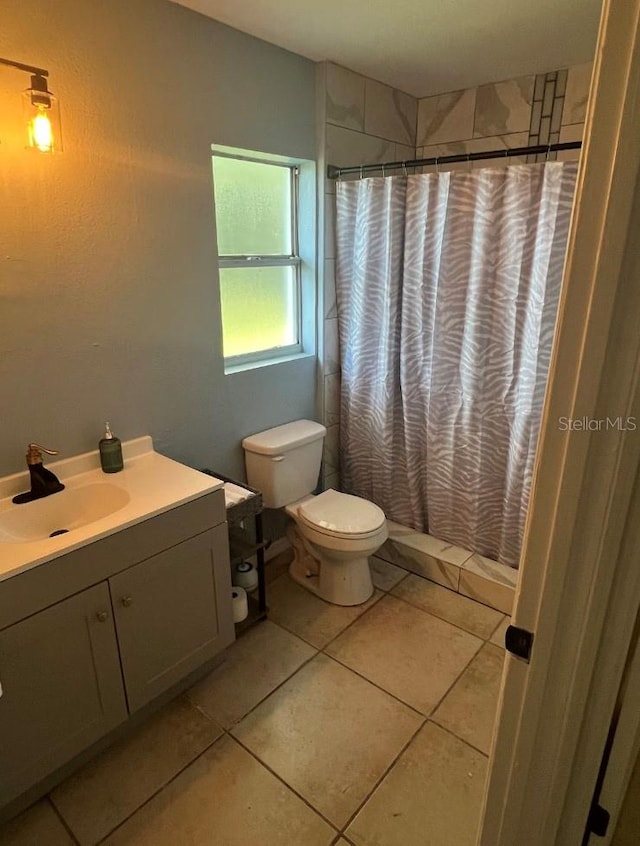 bathroom with vanity, a shower with curtain, toilet, and tile patterned floors