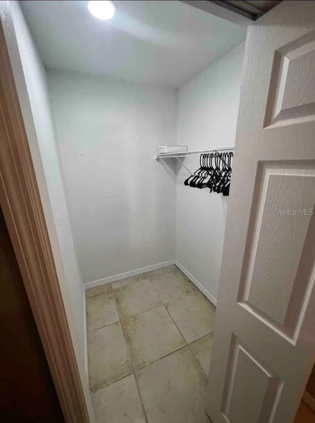 spacious closet with light tile patterned floors