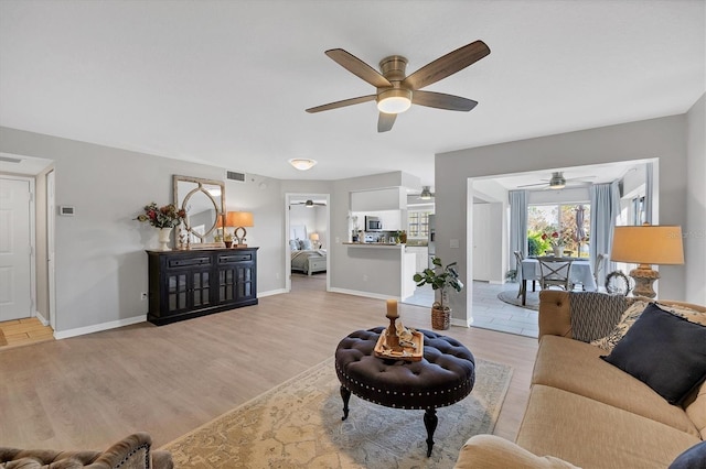 living room with ceiling fan and light wood-type flooring