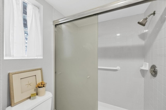 bathroom featuring toilet and a shower with door