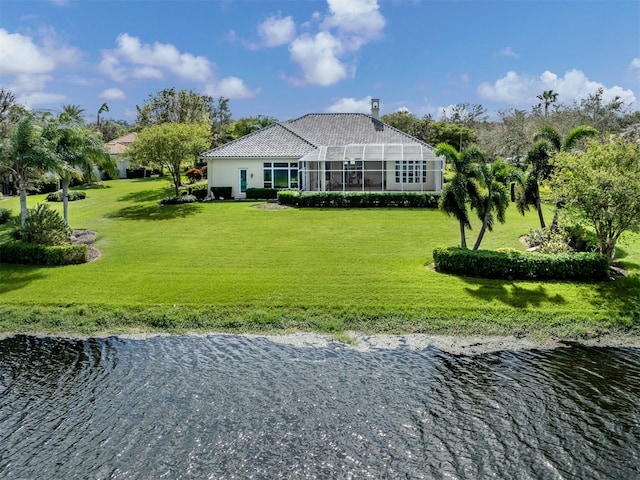 rear view of property with a water view, glass enclosure, and a yard