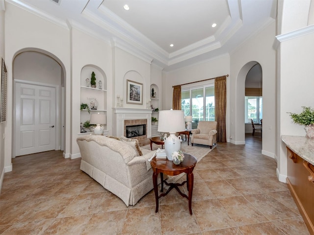 living room featuring ornamental molding, a high ceiling, and built in shelves