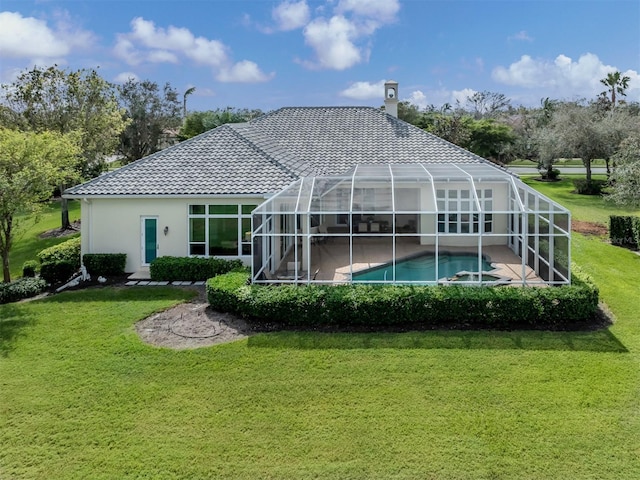 back of property with a lawn and glass enclosure