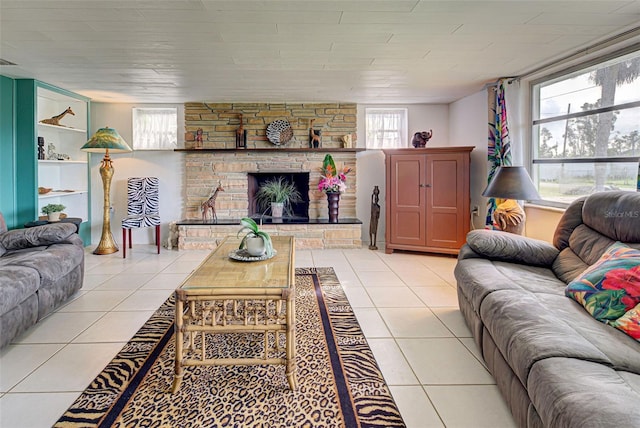 living area featuring a stone fireplace and light tile patterned flooring