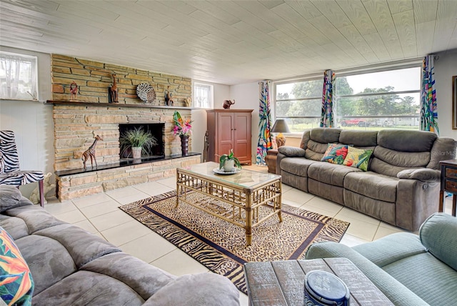 tiled living room featuring a stone fireplace and wooden ceiling