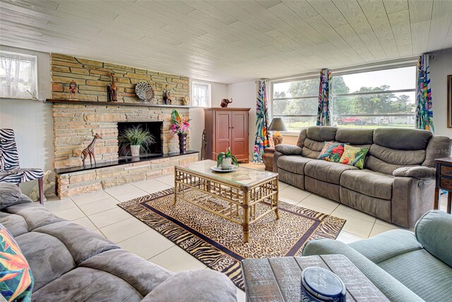 living area featuring wooden ceiling, a stone fireplace, and light tile patterned flooring