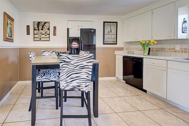 kitchen with ornamental molding, black appliances, light tile patterned floors, white cabinetry, and tasteful backsplash