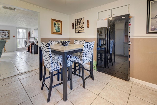 dining area featuring crown molding and light tile patterned floors