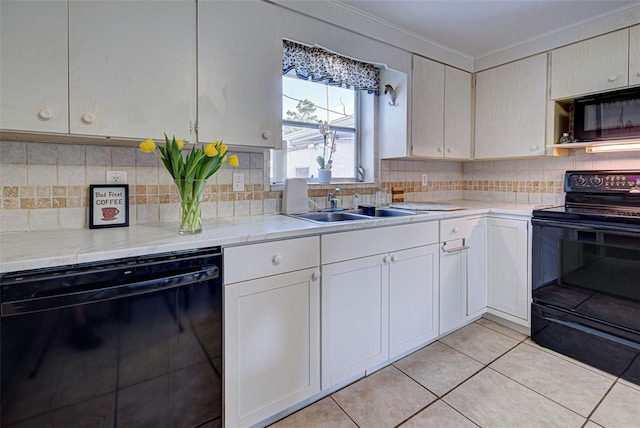 kitchen with crown molding, decorative backsplash, a sink, light tile patterned floors, and black appliances