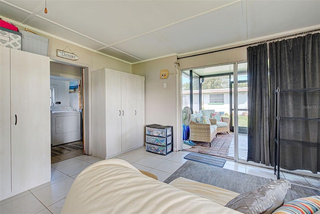 living room featuring ornamental molding, light tile patterned flooring, and washer / clothes dryer
