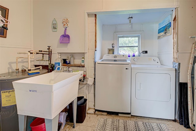 clothes washing area featuring sink and separate washer and dryer