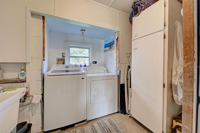 clothes washing area with washing machine and clothes dryer, laundry area, and a sink