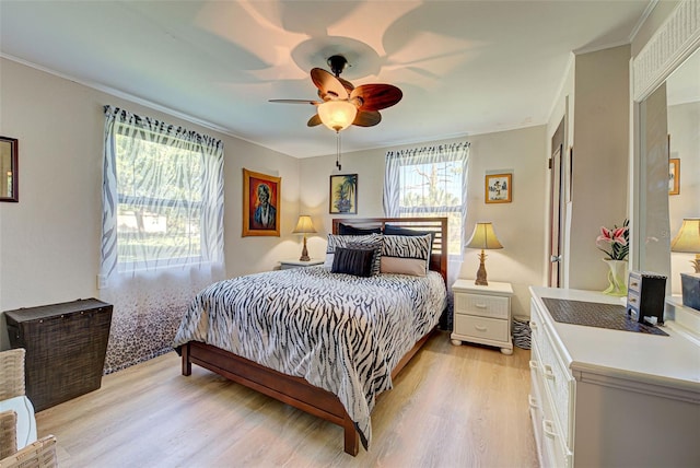 bedroom with ceiling fan, crown molding, and light hardwood / wood-style floors