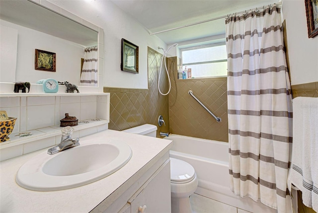 bathroom with shower / bath combination with curtain, tile walls, a wainscoted wall, vanity, and toilet
