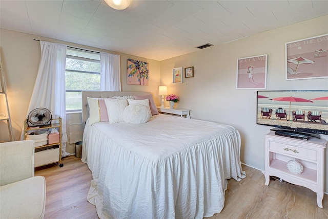 bedroom featuring visible vents and wood finished floors