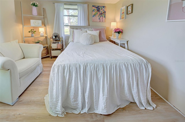 bedroom with baseboards and wood finished floors