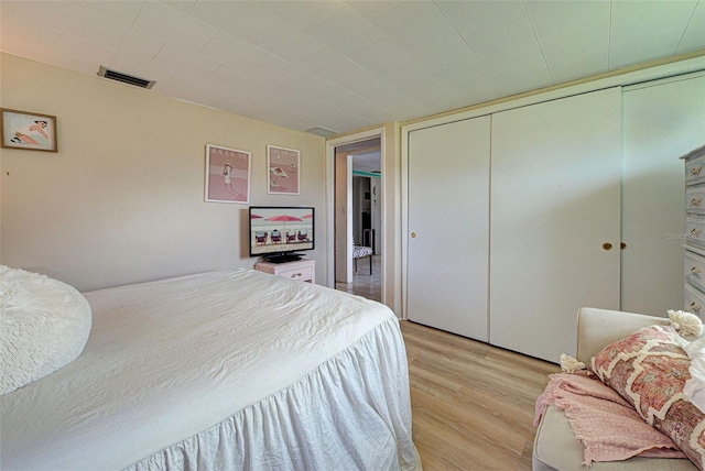 bedroom featuring a closet, light wood-style flooring, and visible vents