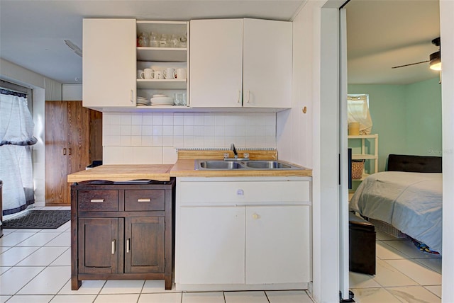 kitchen featuring backsplash, dark brown cabinets, sink, and white cabinets