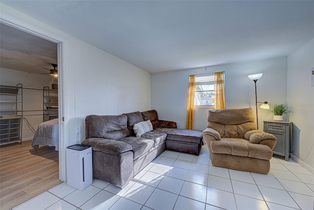 living area with a ceiling fan and light tile patterned floors