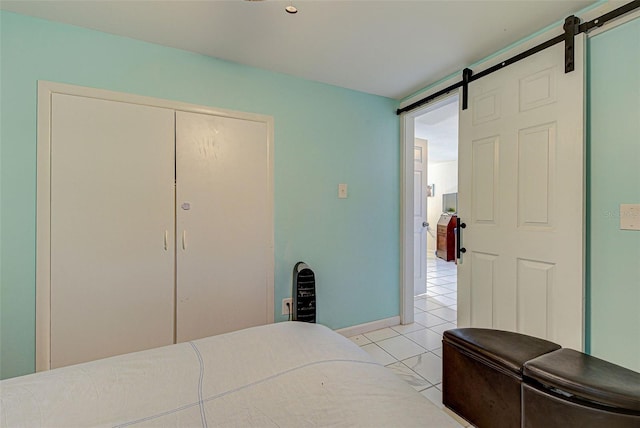 bedroom featuring baseboards, a closet, and a barn door