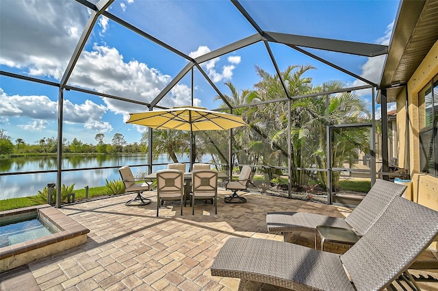 view of patio with a water view, glass enclosure, and a jacuzzi