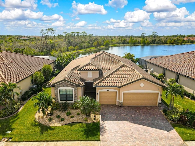 view of front of home with a water view, a garage, and a front lawn