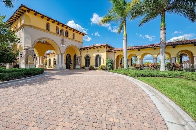 view of front of home featuring decorative driveway, a tile roof, and stucco siding