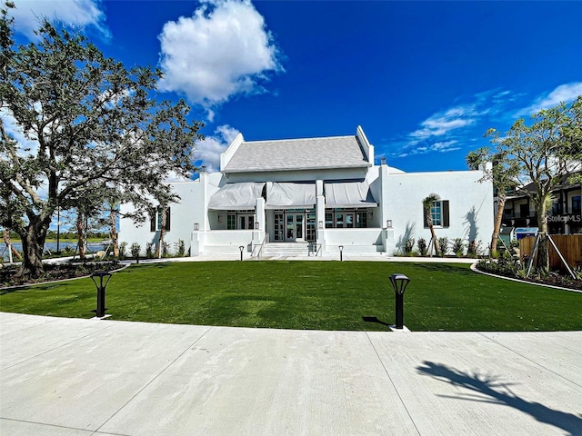 view of front of property featuring a front lawn and stucco siding